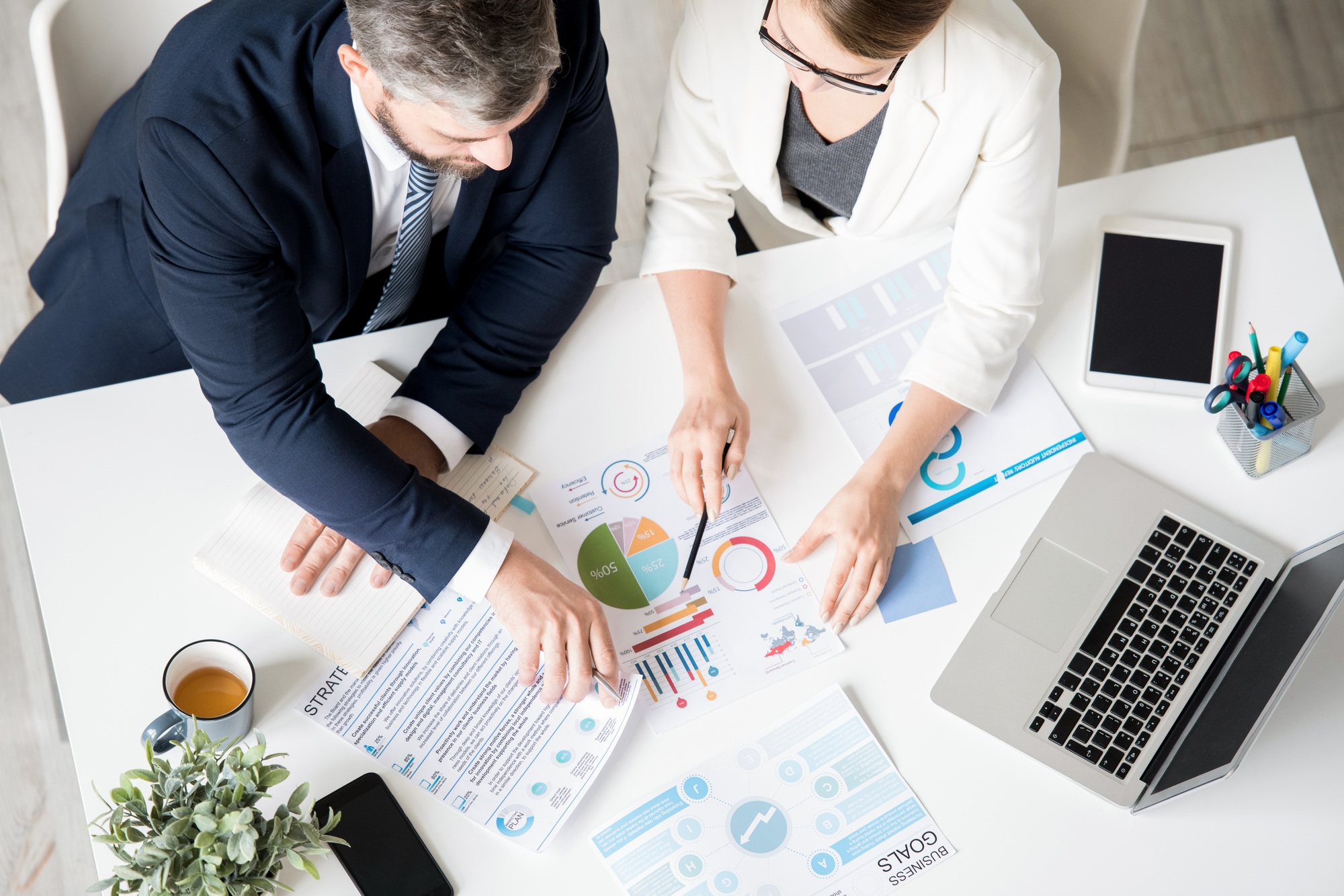 Business specialists analyzing progress while viewing charts